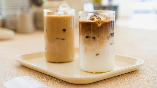 two tall glasses of iced coffee on a tray